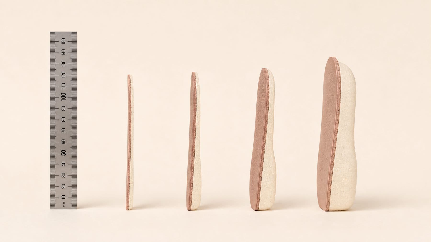 Four insole cross-sections side by side showing increasing padding thickness against a millimetre rule.